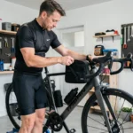Cycliste installant un sac de guidon ergonomique sur un vélo Triban RC 120 dans un garage équipé