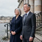 Couple élégant devant un bâtiment néoclassique européen illustrant le parcours d'Annaliese Witschak et George Soros