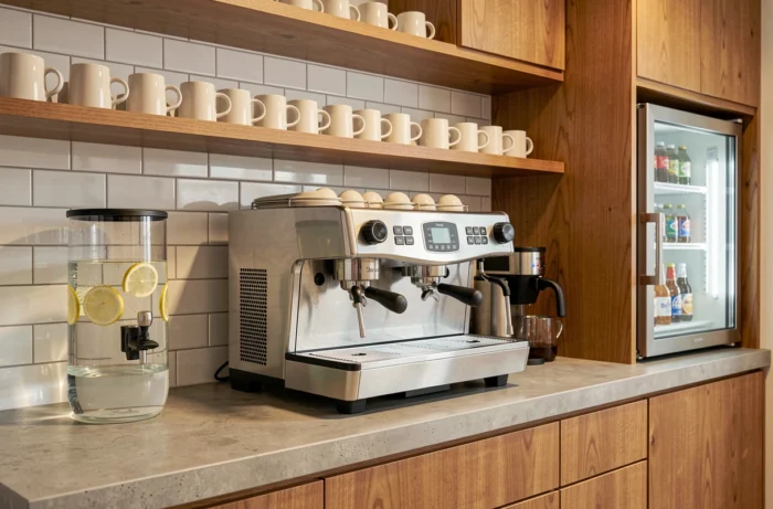 Coin café de bureau équipé d'une machine à expresso, de mugs, d'un distributeur d'eau fraîche et d'un petit réfrigérateur