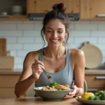Femme sportive mangeant un repas équilibré de poulet grillé et quinoa après l'entraînement dans une cuisine moderne
