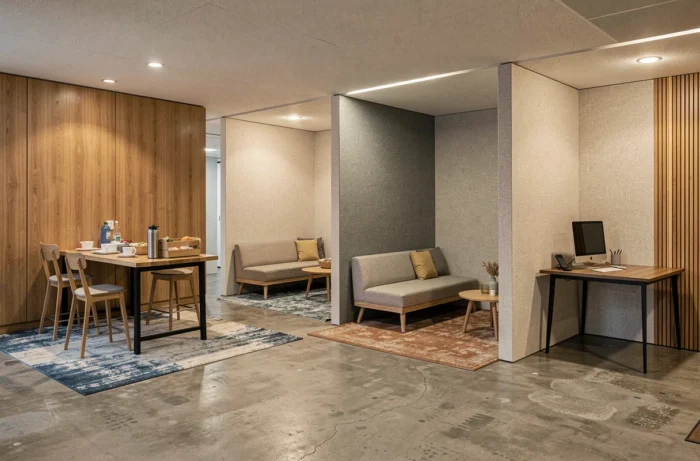 Salle de pause divisée en plusieurs zones d'usage distinctes avec coin repas, espace détente et table de travail